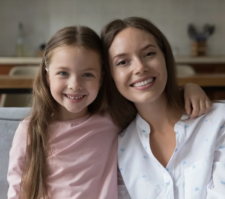 Une mère et sa fille souriantes, assises côte à côte